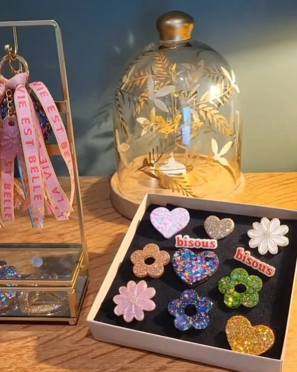 Boucles d'oreilles en résine pailletée présentées dans un coffret, dans l'atelier de Vannes